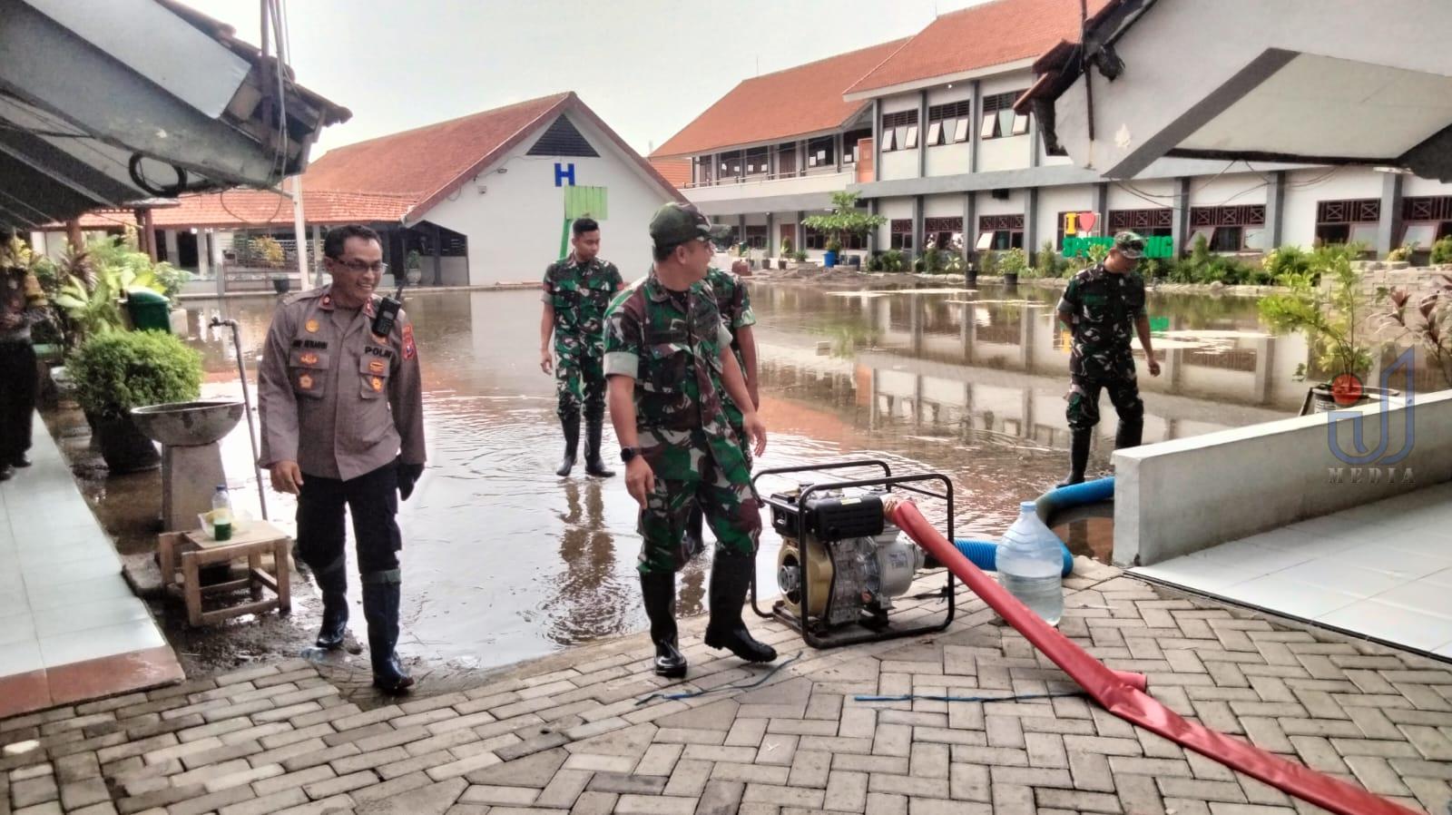 Petugas gabungan saat melakukan pemompaan genangan air di lokasi banjir